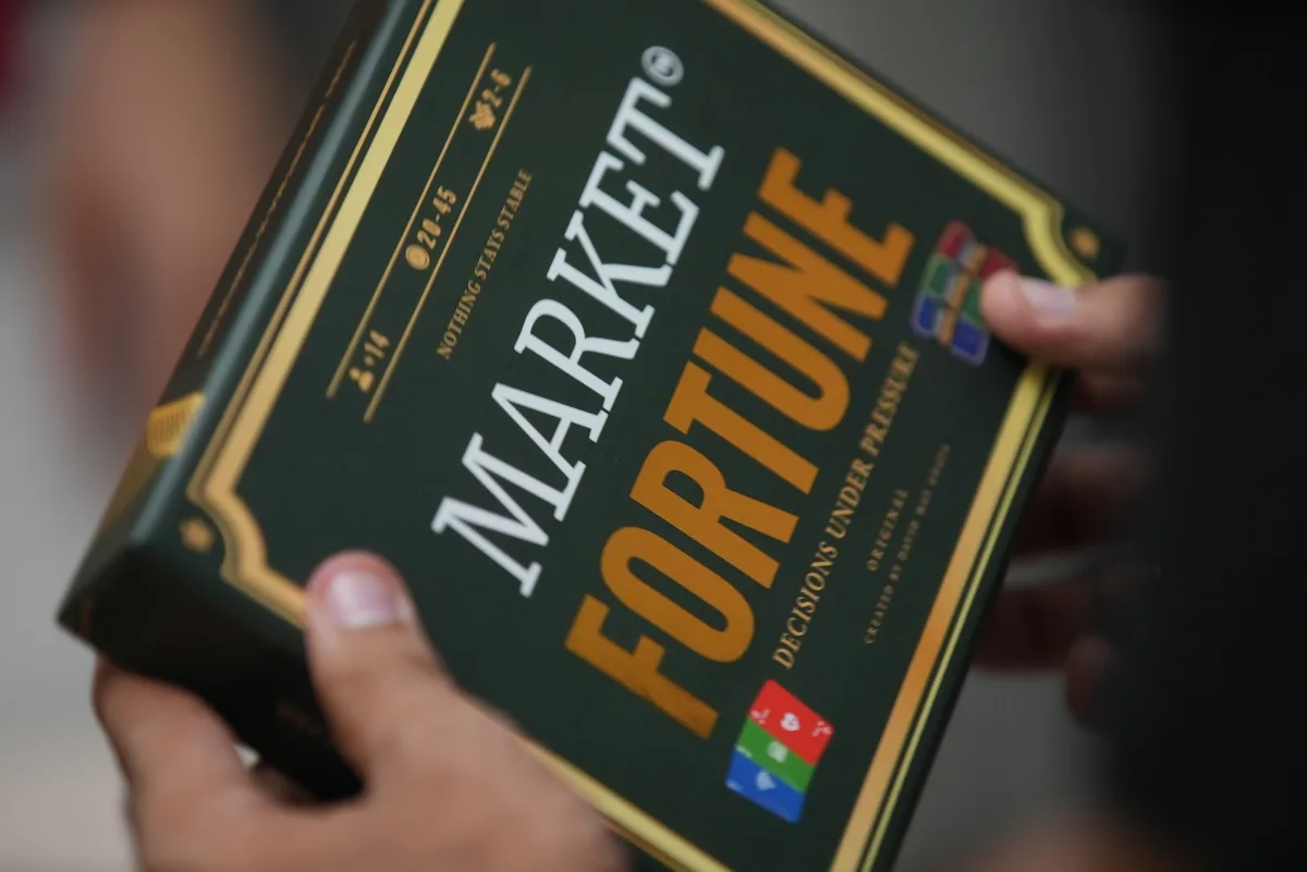 La caja de Market Fortune sostenida con las dos manos.
