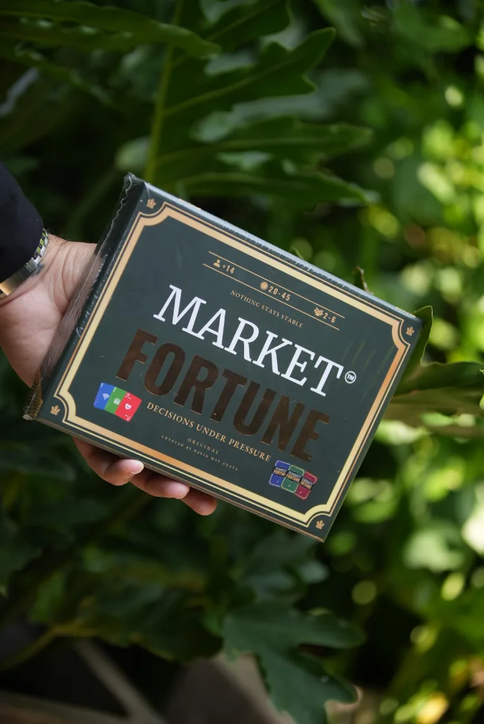 La caja en mano, con vegetación de Cartagena detrás.